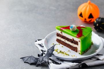 Halloween cake on a white plate with holiday table decoration. Grey background. Copy space.