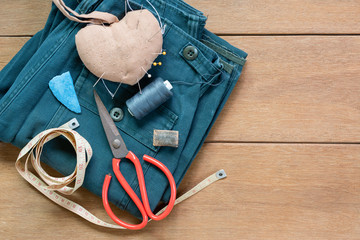 top view of accessories for clothing repair on wooden table. tailor work and maintenance concept