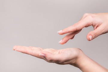 Closeup view of two beautiful manicured white female hands in gesture of empty hand supporting...