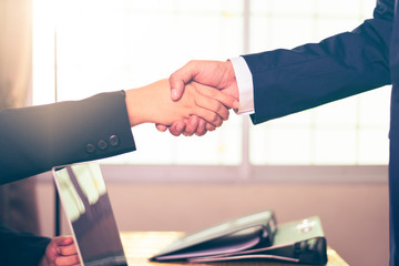 Obraz na płótnie Canvas Asian businessman and businesswomen Handshaking at office background.Successful businessmen handshaking after good deal.Handshake Gesturing People Connection Deal Concept.