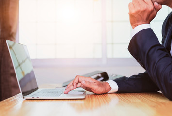 Asian businessman hands on the keyboard Working at home office with laptop,Data Processing business concept.