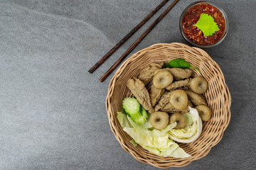 Meatballs with spicy sauce in basket on table.