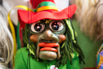 Selective focus of a ugly green puppet handmade from Prague