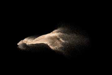 Dry river sand explosion. Golden colored sand splash against  black background.