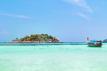 Fototapeta na wymiar Tropical island with azure blue ocean and boat