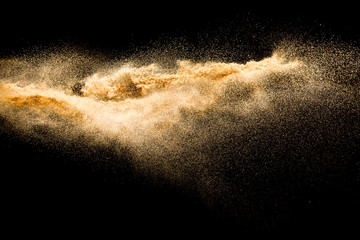 Plakat Dry river sand explosion. Golden colored sand splash against black background.