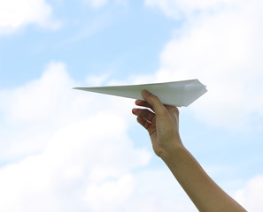 Hand holding paper airplane