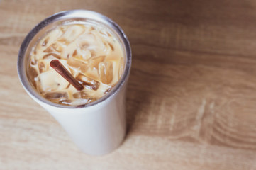 a bottle of iced coffee and brown plastic straw on wood surface table