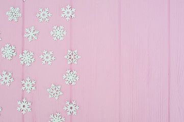 white christmas snowflakes decoration on pink wooden background with place for your text. xmas wallpaper. flat lay, top view