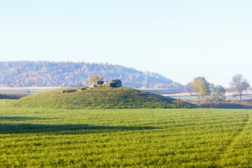 Fototapeta na wymiar Stone Age grave on a hill in a rural landscape