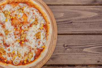 Hawaiian pizza on dark rustic wooden background. Top view, copy space