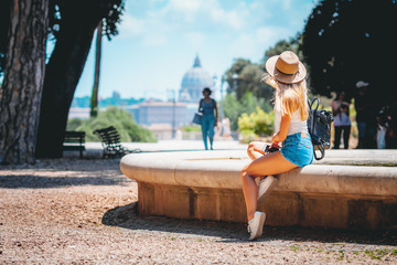 Rome Europe Italia travel summer tourism holiday vacation background -young smiling girl with mobile phone camera and map in hand standing on the hill looking on the cathedral Vatican