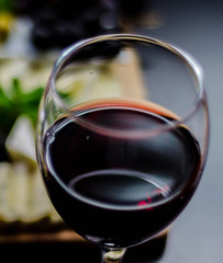 Red wine and set of different cheeses on a wooden board, delicious snack