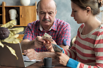 Olderly Spanish man gives his daughter money for a mortgage or student loan. Helping children while...