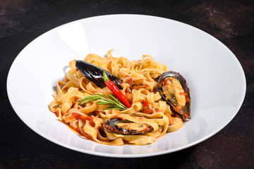 Homemade pasta with mussels, sprinkle with chopped parsley and basil. Delicious of pasta with mussel