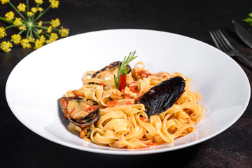 Homemade pasta with mussels, sprinkle with chopped parsley and basil. Delicious of pasta with mussel