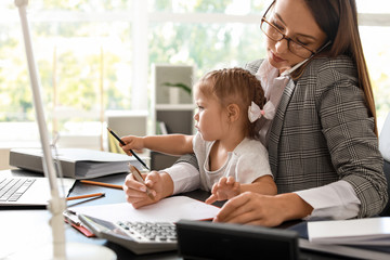 Working mother with her daughter in office