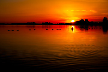 Naklejka premium Orange sky in sunset over the lake