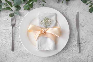 Beautiful table setting with flowers and eucalyptus on grey background
