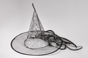 Transparent satin witch magic hat for Halloween. Black witch hat with black hair isolated on white...