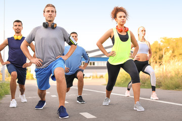 Group of sporty young people training outdoors