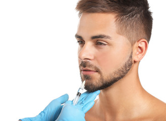 Obraz premium Handsome man receiving filler injection on white background
