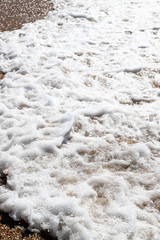Sea wave, foam and spray. Ocean whitecaps at sandy beach