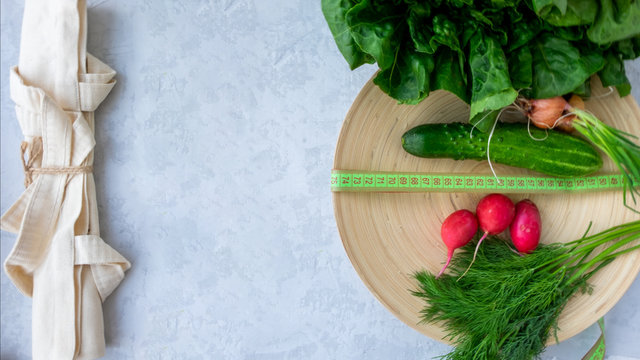 Cotton bag fitness salad, cucumber, radish, dill and centimeter on bamboo plate. The concept of ecology and healthy food, diet and weight loss.