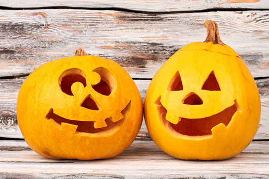 Funny Halloween pumpkin on wooden background. Preparation for Halloween. Head carved from a pumpkin for Halloween holiday.