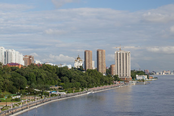 Naklejka premium Amur River embankment of city of Khabarovsk, Russia. On summer day, people walk, play sports, sunbathe in sun.