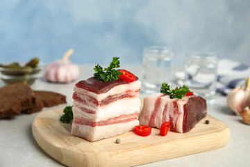 Composition with bacon and chili pepper on table against blue background
