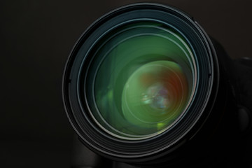 Lens of professional camera on black background, closeup