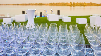 A lot of wine glasses in a row. Luxury glasses for alcohol. Wine glasses with wine on a table outside