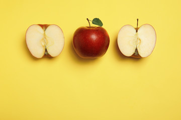 Flat lay composition with ripe juicy red apples on yellow background, space for text