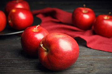 Ripe juicy red apples on black wooden table