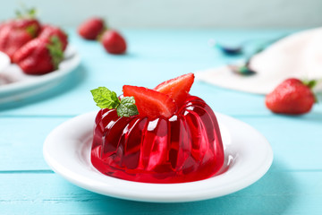 Delicious red jelly with strawberry and mint on light blue wooden table