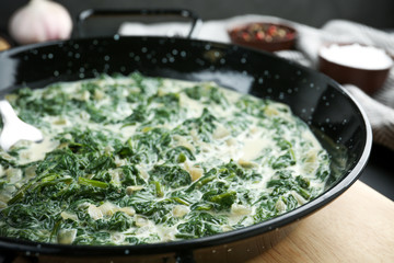 Tasty spinach dip in frying pan on table, closeup