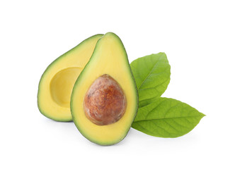 Halves of fresh ripe avocado and leaves on white background