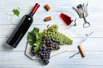 Flat lay composition with fresh ripe juicy grapes and wine on white wooden table