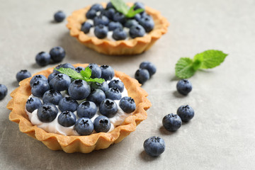 Delicious sweet pastry with berries on grey table. Space for text