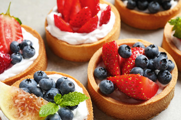 Delicious sweet pastries with berries on grey table, closeup