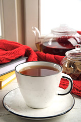 Cup of hot tea on window sill. Winter drink