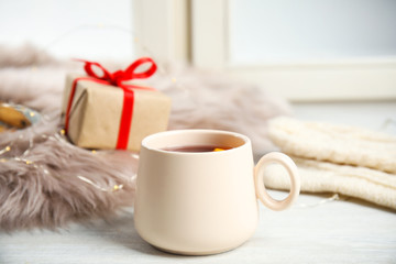 Cup of hot winter drink on window sill