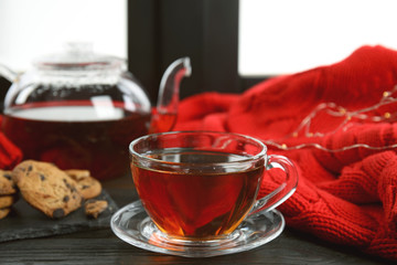 Cup of hot tea on window sill. Winter drink
