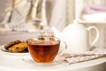 Cup of hot tea on white table indoors. Winter drink