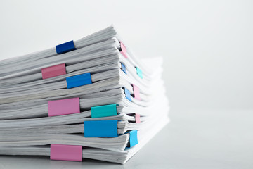 Stack of documents with binder clips on light table, closeup. Space for text