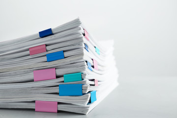 Stack of documents with binder clips on light table, closeup. Space for text