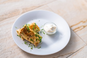 Homemade pancakes with filling and sour cream