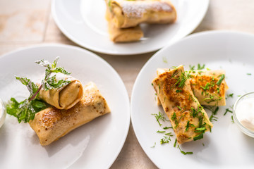 Homemade pancakes with filling and sour cream