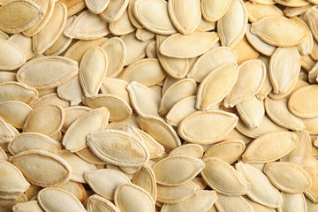 Raw unpeeled pumpkin seeds as background, top view